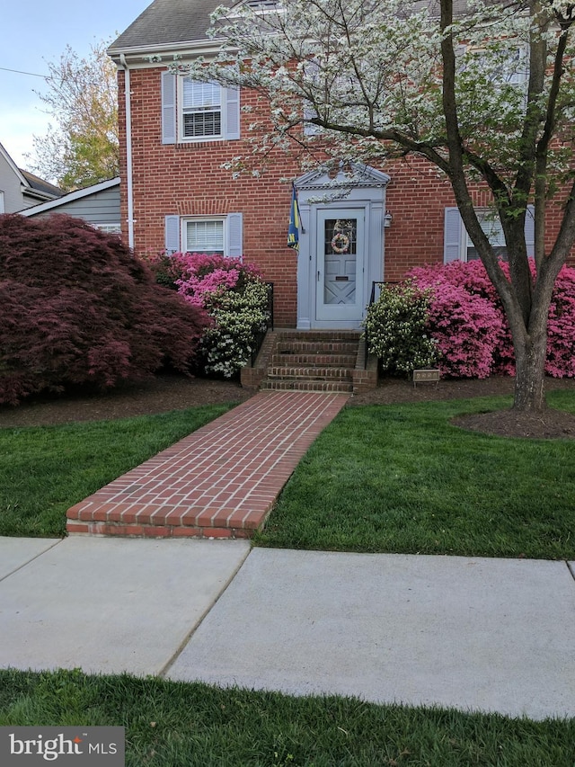 view of exterior entry with a lawn