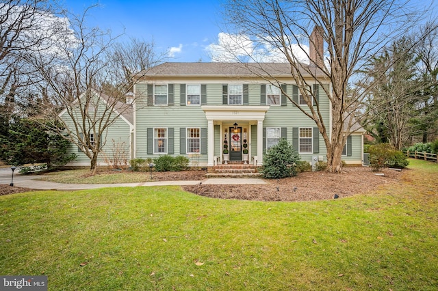 colonial home with a front lawn