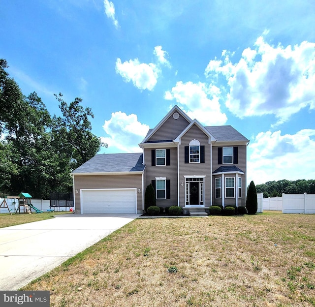 view of front of house with a garage, a front lawn, and a playground