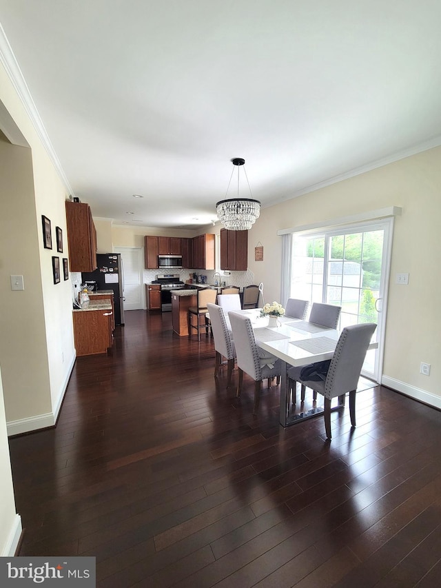 dining area with crown molding, dark hardwood / wood-style floors, and a chandelier