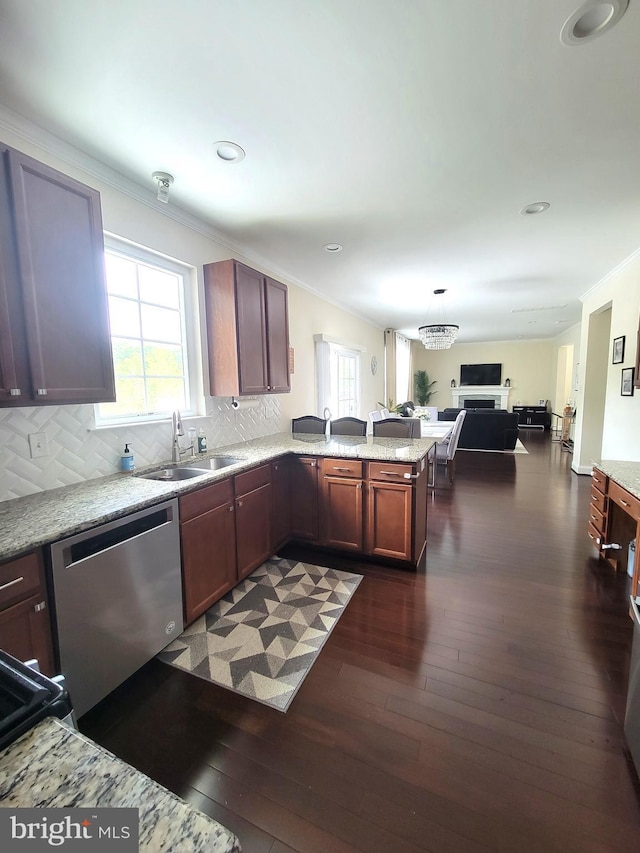 kitchen with dark hardwood / wood-style flooring, sink, stainless steel dishwasher, and kitchen peninsula