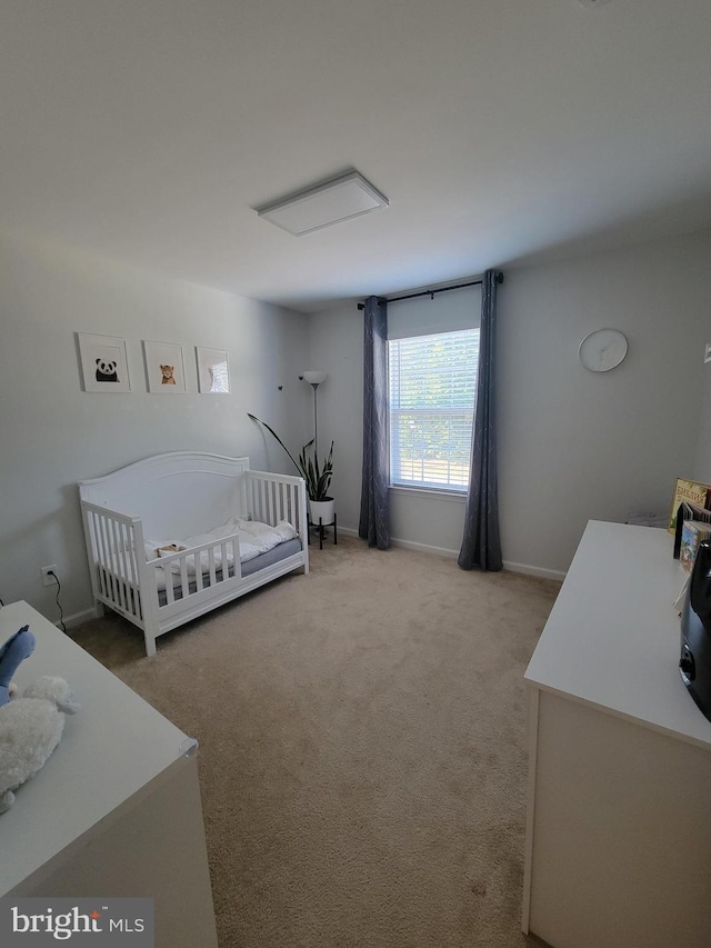 carpeted bedroom featuring a nursery area