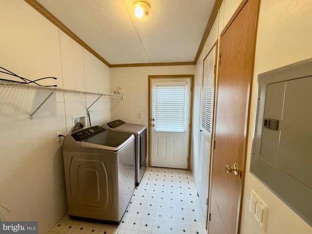 clothes washing area with crown molding, light floors, washing machine and clothes dryer, a textured ceiling, and laundry area