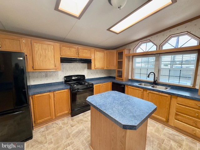 kitchen featuring lofted ceiling with skylight, a sink, a kitchen island, under cabinet range hood, and black appliances