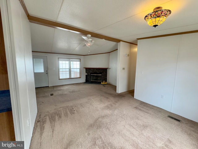 unfurnished living room featuring visible vents, a fireplace with raised hearth, ornamental molding, vaulted ceiling with beams, and carpet flooring