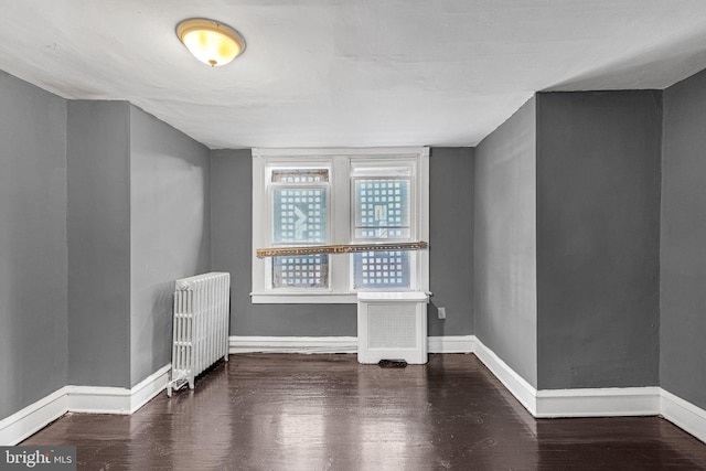 interior space with radiator and dark hardwood / wood-style flooring