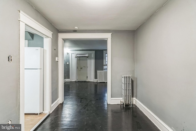 hall with radiator and hardwood / wood-style floors