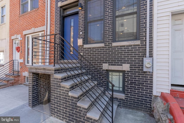 doorway to property featuring brick siding