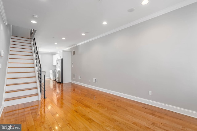 unfurnished living room featuring light wood-style flooring, ornamental molding, baseboards, stairway, and recessed lighting