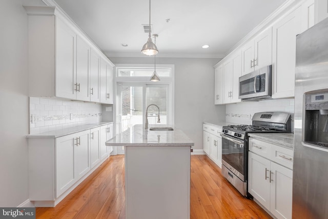 kitchen featuring a sink, hanging light fixtures, a kitchen island with sink, white cabinetry, and stainless steel appliances