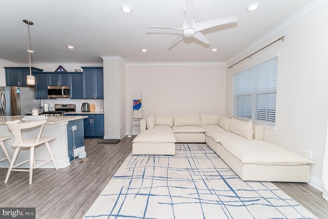 living room featuring ornamental molding, light wood-type flooring, recessed lighting, and a ceiling fan