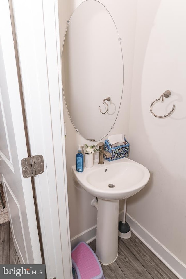 bathroom with baseboards and wood finished floors