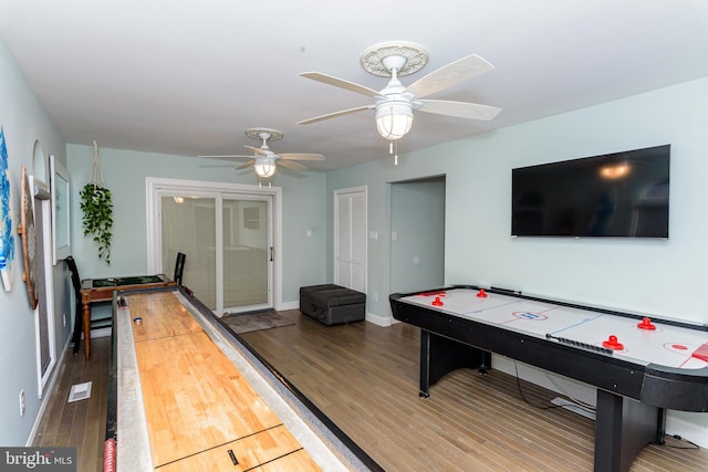 rec room with visible vents, baseboards, and wood finished floors