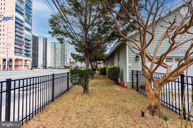 view of yard with a view of city and fence