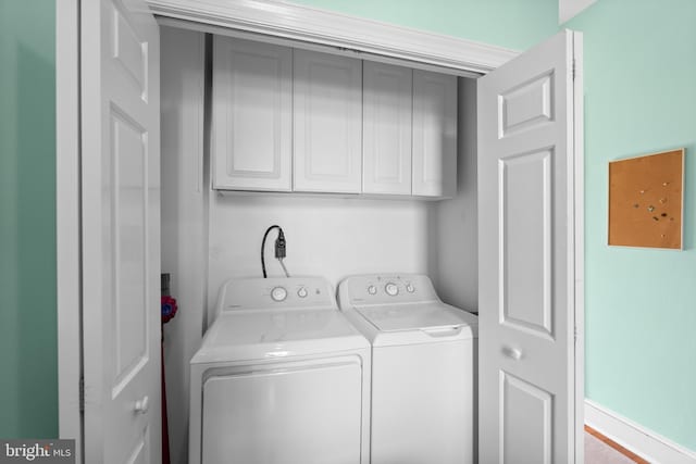 washroom with washer and clothes dryer and cabinet space