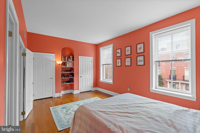 bedroom with baseboards and wood finished floors