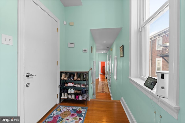 hall with light wood-style flooring and baseboards