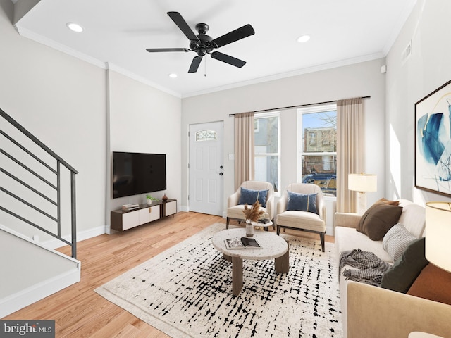 living room with ornamental molding, hardwood / wood-style flooring, and ceiling fan