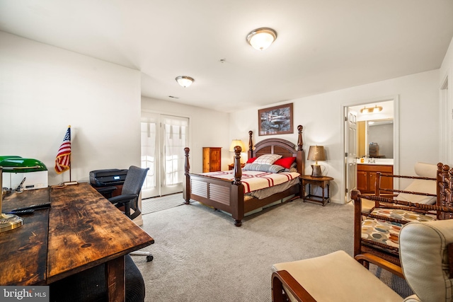 bedroom featuring connected bathroom, access to outside, and light colored carpet