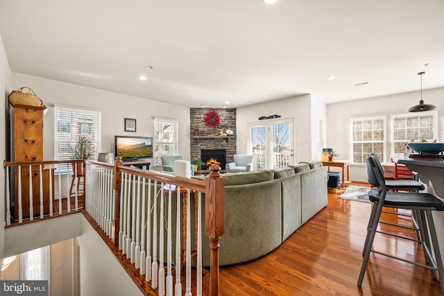 living room with a wealth of natural light, wood-type flooring, and a fireplace