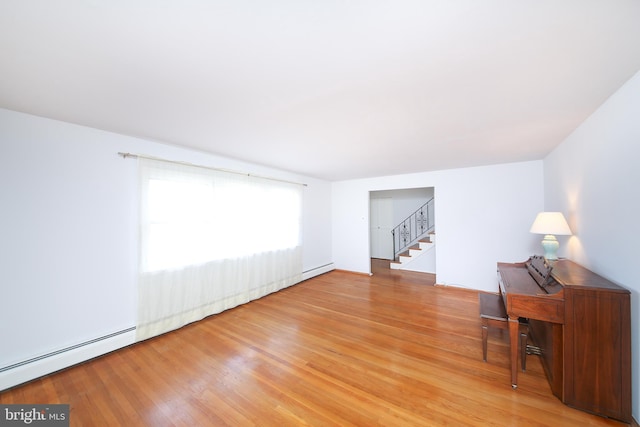 interior space featuring a baseboard heating unit and hardwood / wood-style flooring