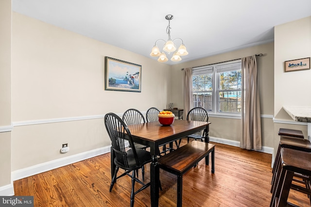 dining space featuring hardwood / wood-style flooring and a notable chandelier