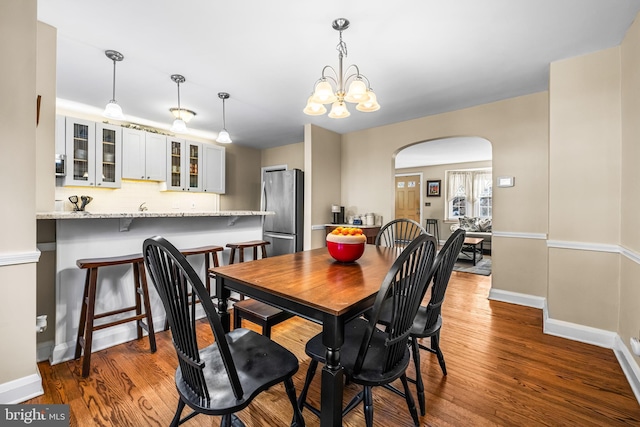 dining space with an inviting chandelier and hardwood / wood-style flooring