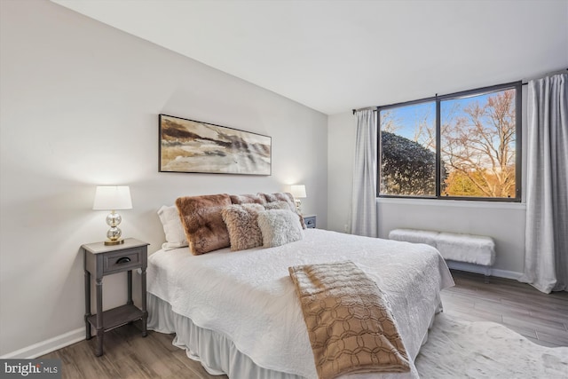 bedroom featuring baseboards and wood finished floors