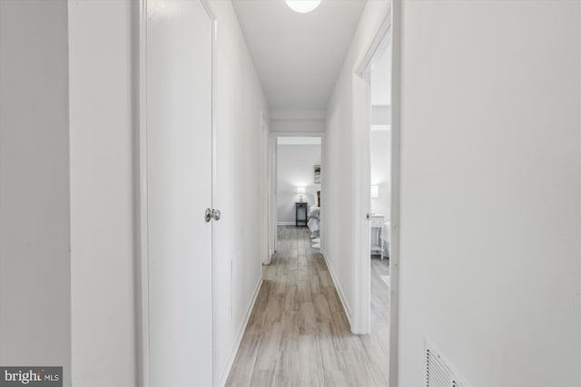 corridor featuring light wood finished floors and visible vents