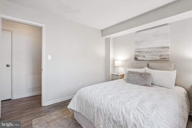 bedroom with wood finished floors and baseboards