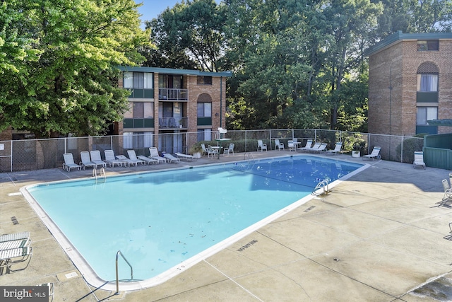 pool featuring fence and a patio