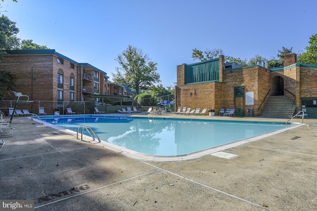 community pool featuring a patio area and fence