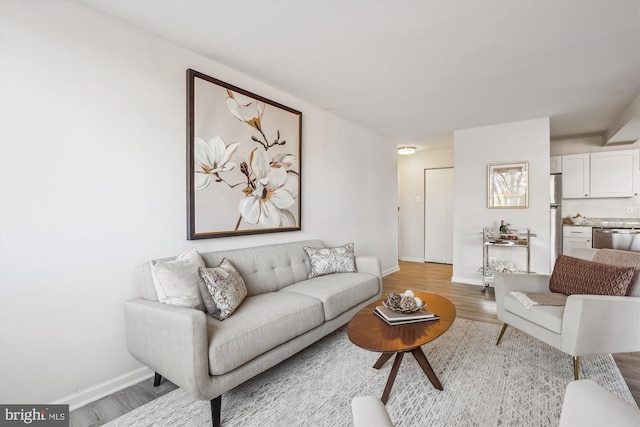 living area featuring baseboards and wood finished floors