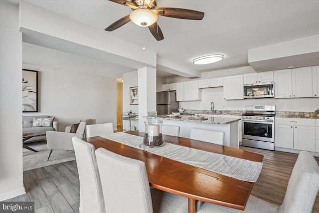 dining room featuring a ceiling fan and wood finished floors