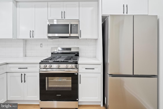 kitchen featuring backsplash, stainless steel appliances, and white cabinets