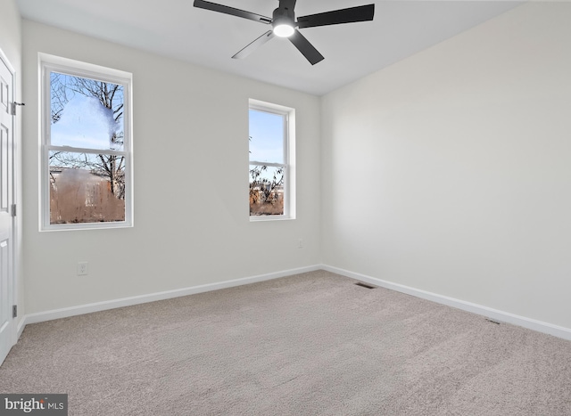 carpeted spare room with ceiling fan