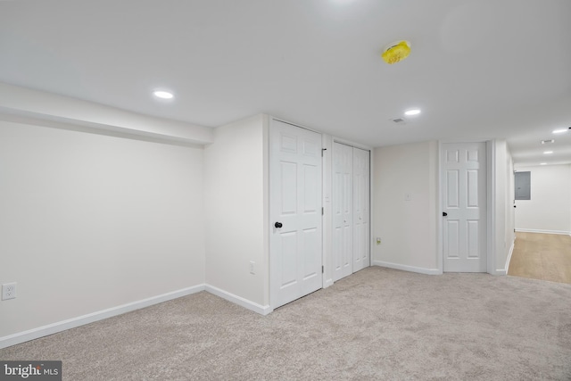 basement featuring light colored carpet and electric panel