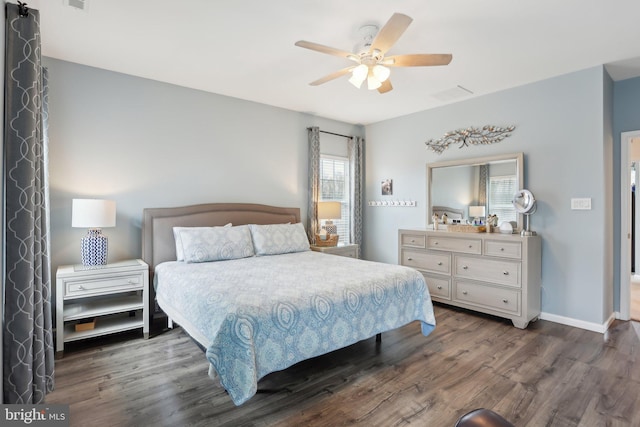 bedroom with dark wood-style floors, visible vents, ceiling fan, and baseboards