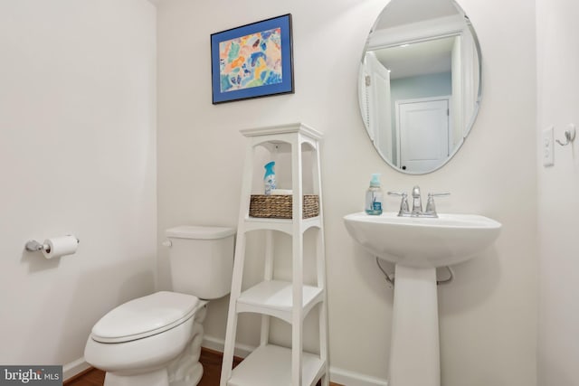 bathroom with toilet and baseboards