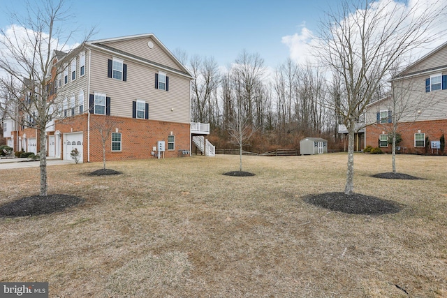 view of property exterior featuring stairway, an attached garage, an outdoor structure, a shed, and brick siding