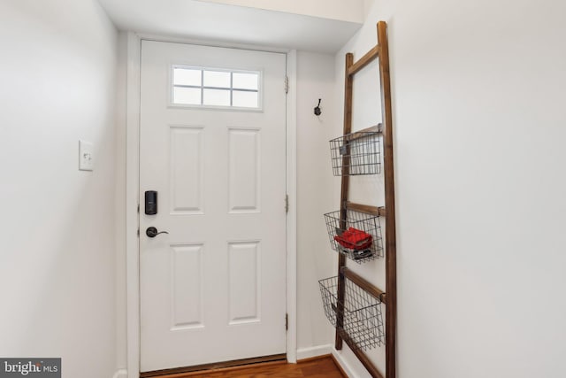 doorway with wood finished floors and baseboards