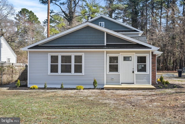 view of front of home with a front yard, fence, and brick siding