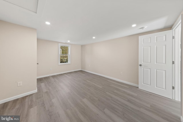 spare room with recessed lighting, baseboards, and wood finished floors