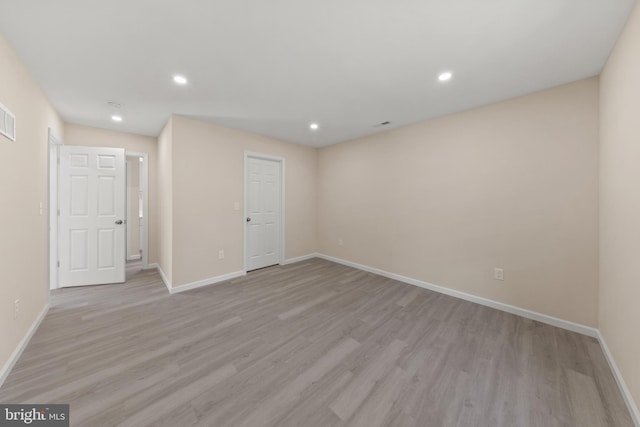 spare room featuring recessed lighting, light wood-style floors, and baseboards