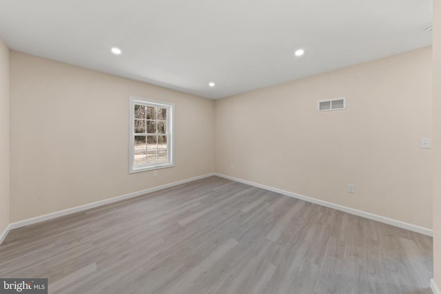 unfurnished room featuring recessed lighting, light wood-style floors, visible vents, and baseboards