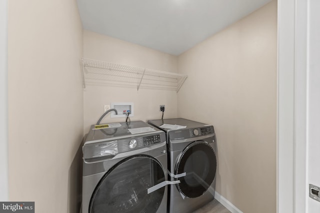 clothes washing area featuring washer and dryer, baseboards, and laundry area