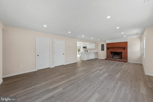 unfurnished living room featuring a fireplace, recessed lighting, light wood-style floors, and baseboards