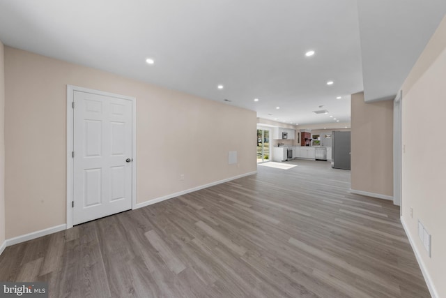 unfurnished living room with recessed lighting, visible vents, baseboards, and light wood-style floors