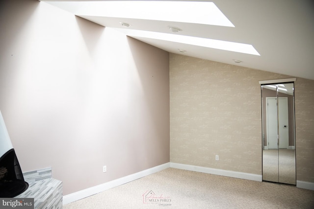 interior space with carpet flooring and lofted ceiling with skylight