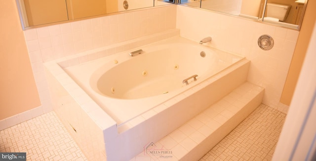 bathroom with tiled bath and tile patterned flooring